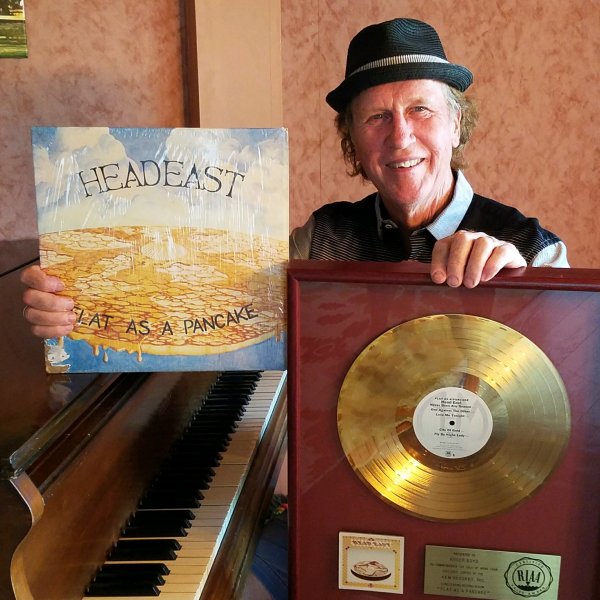 Head East band leader Roger Boyd holding the RIAA Gold Record Award
and original Flat As A Pancake LP recorded at Golden Voice Recording Studio.
Photo by Head East Head East band leader Roger Boyd holding the RIAA Gold Record Award
and original Flat As A Pancake LP recorded at Golden Voice Recording Studio.
Photo by Head East